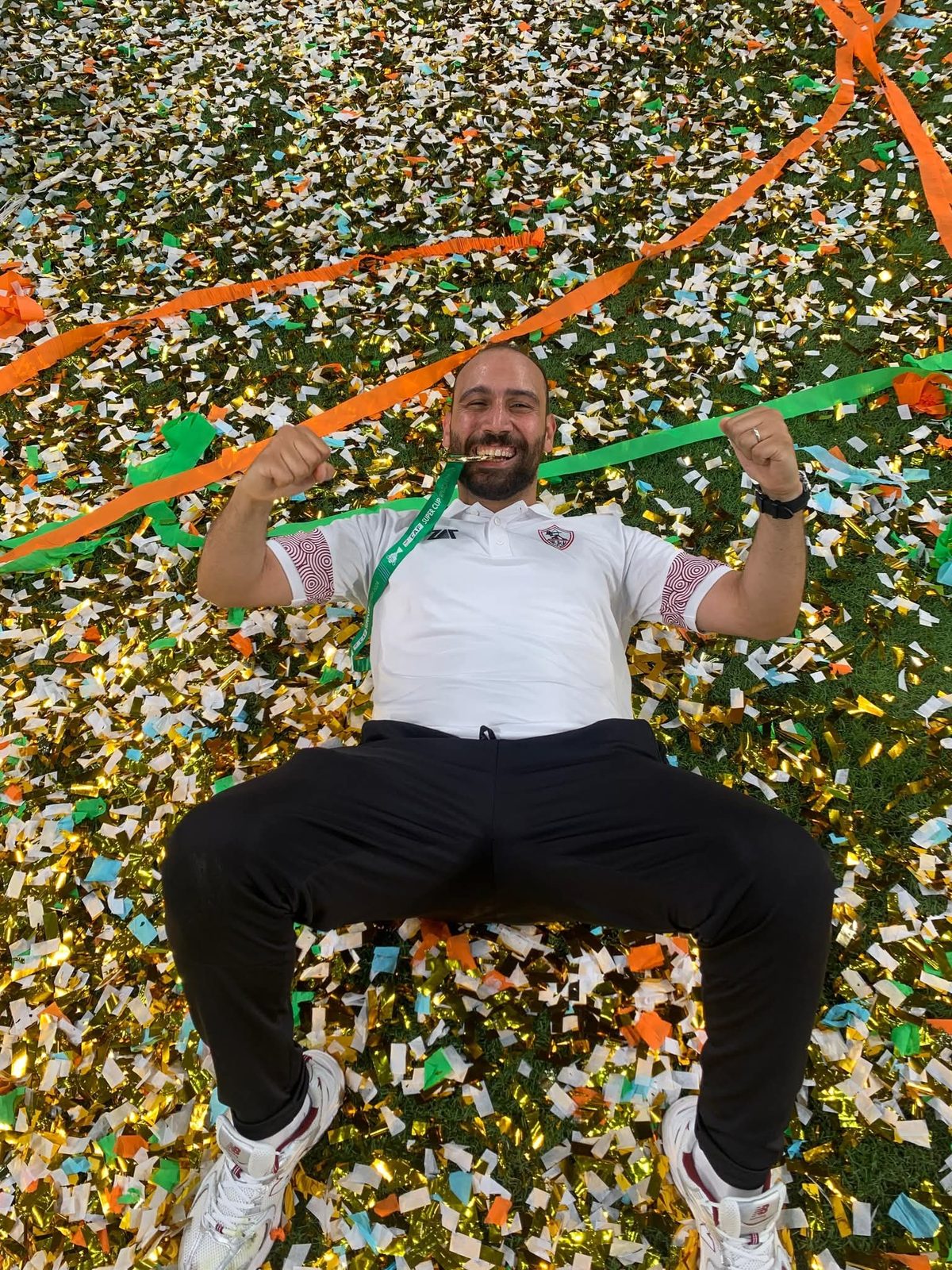 Graduate celebrating in confetti on pitch