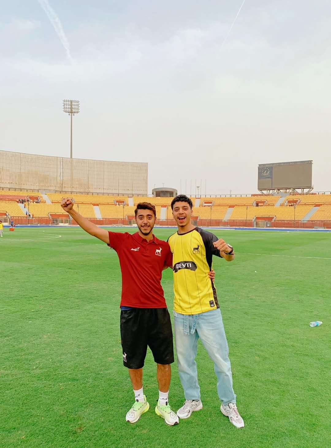 Two graduates celebrating at stadium