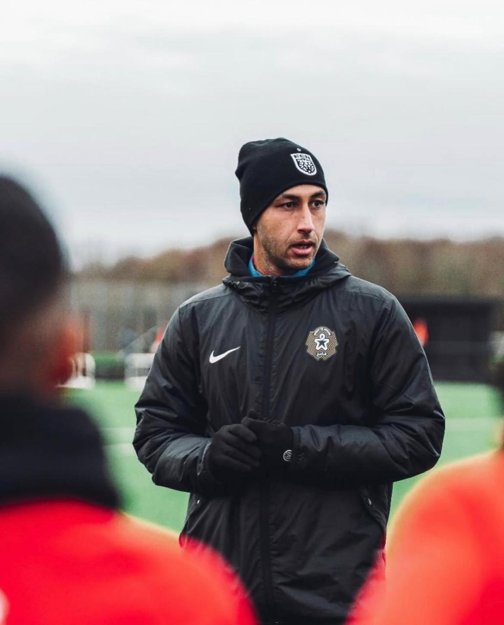 Coach addressing players in winter gear